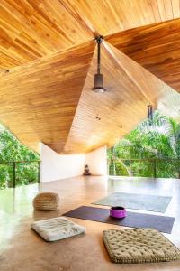una habitación con techo de madera y una habitación con esterillas en Entire Nosara Tree House, en Nosara