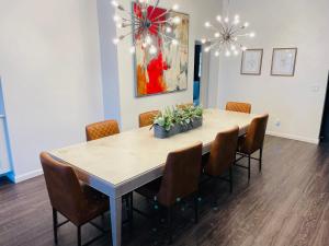 a dining room table with chairs and a painting on the wall at Sandstone Ridge Apartments Remodeled 6 Bedroom 4 Bath in Oklahoma City