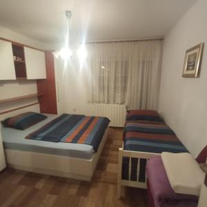 Un dormitorio con 2 camas y una silla. en Apartman Dražice-Grobnik en Dražice