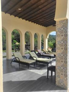una fila de sillas y mesas en un patio en Acogedora Cabaña en Sopetran en Otrabanda