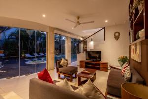 a living room with a couch and a tv at Villa Belle Seminyak by Bali Villas R Us in Seminyak