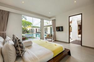 a bedroom with a large bed and a large window at Villa Belle Seminyak by Bali Villas R Us in Seminyak