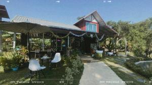 uma casa com cadeiras e um guarda-sol em frente em C-Code Resort em Lom Sak