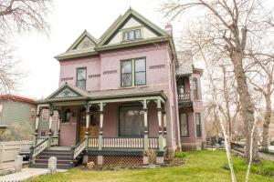 a pink house with a front porch at Pope House - Hist. Mansion - The Wild(e) Suite in Helena