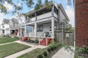 a white house with red stairs and a fence at Modern 2BR near DT, 8min walk to Park&Conservatory in Columbus