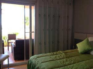 トレ・パチェコにあるLuxury appartment on golf resortのベッドルーム1室(ベッド1台付)、スライド式ガラスドアが備わります。