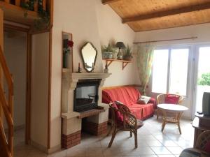 a living room with a red couch and a fireplace at Maison La Bernerie-en-Retz, 3 pièces, 6 personnes - FR-1-612-113 in La Bernerie-en-Retz