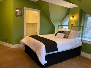 a bedroom with a large bed with green walls at Pope House - Hist. Mansion - The Green Suite in Helena
