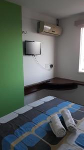 une chambre avec un lit avec deux oreillers dessus dans l'établissement Suites Vila de Iracema, à Fortaleza