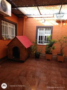 una casa de perros con techo rojo en una habitación con plantas en Eris 1 en Godoy Cruz