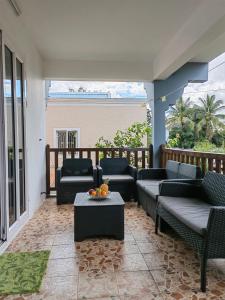 a patio with couches and a table on a balcony at Residence Devika2 Trou aux Biches in Trou aux Biches