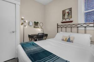 um quarto com uma cama branca e uma secretária em Modern 2BR near DT, 8min walk to Park&Conservatory em Columbus