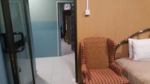 a room with a chair and a bed and a phone at The Winford Boutique Hotel Airport in Accra