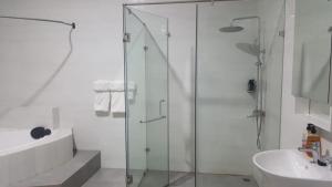 a bathroom with a glass shower and a sink at The Winford Boutique Hotel Airport in Accra