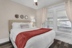 a white bedroom with a large bed and a window at Chic 2BR near DT, 8 min walk to Park&Conservatory in Columbus