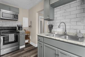 a kitchen with a sink and a stove at Chic 2BR near DT, 8 min walk to Park&Conservatory in Columbus