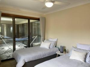 a room with two beds and a balcony at Taranaki Penthouse - wonderful in Port Macquarie