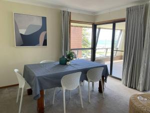 a dining room with a blue table and chairs at Taranaki Penthouse - wonderful in Port Macquarie
