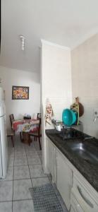 a kitchen with a sink and a counter top at Apartamento na avenida da praia in Praia Grande