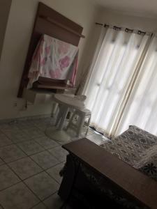 a living room with a piano in front of a window at Apartamento na avenida da praia in Praia Grande