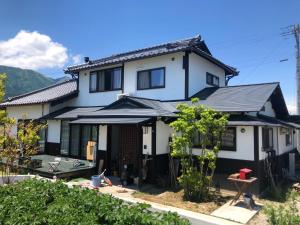 una casa blanca con techo negro en Azumino Fukuro Guesthouse - Vacation STAY 27117v, en Azumino