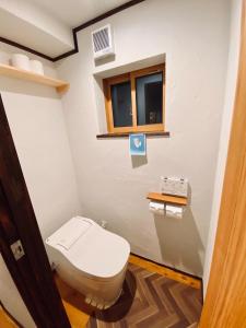 a bathroom with a toilet and a window at Azumino Fukuro Guesthouse - Vacation STAY 27117v in Azumino