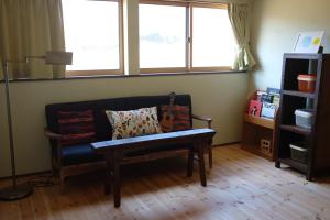 sala de estar con sofá y 2 ventanas en Azumino Fukuro Guesthouse - Vacation STAY 27117v, en Azumino