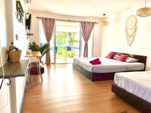 Insook Ko Larn Resort في كو لان: غرفة نوم بسريرين وصالة جلوس