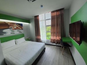 a bedroom with a large bed and a window at PARADIAN HOTEL in Seremban