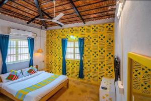 a bedroom with a bed and a yellow wall at Luxury 6 BHK Villa with Private Swimming Pool in Old Goa