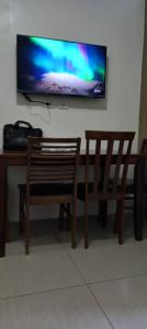 a bench and a flat screen tv on a wall at At the Shore in Manila