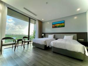 a bedroom with two beds and a large window at DIAMOND HOTEL VÂN ĐỒN in Cẩm Phả +68 photos