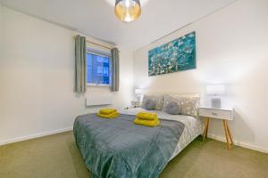 a bedroom with a bed with yellow towels on it at Castle Terrace - Grampian Lettings Ltd in Aberdeen