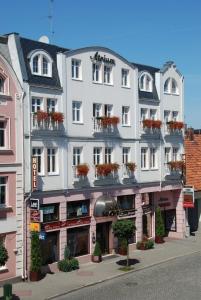 a large white building with flower boxes on it at Hotel Atrium in Nowy Tomyśl