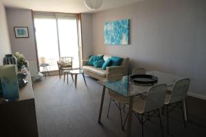 uma sala de estar com um sofá, uma mesa e cadeiras em Bel Appartement vue mer SAINT BREVIN LES PINS em Saint-Brévin-les-Pins