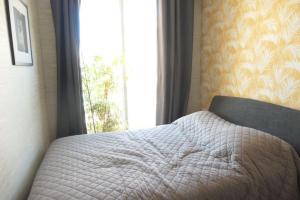 uma cama num quarto com uma janela em Bel Appartement vue mer SAINT BREVIN LES PINS em Saint-Brévin-les-Pins