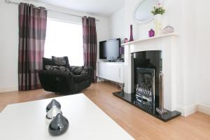 a living room with a fireplace and a chair at ire House Eire House in Coventry