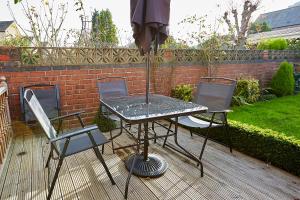 a table and chairs with an umbrella on a patio at ire House Eire House in Coventry