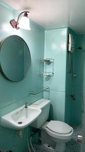 La salle de bains est pourvue d'un lavabo, de toilettes et d'un miroir. dans l'établissement Popular C3-C9 Impact, à Nonthaburi