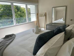 1 dormitorio con 1 cama grande y espejo grande en Noahs Beach House - at Flynns en Port Macquarie