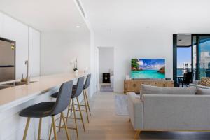 a kitchen and living room with a couch and a table at Signature Broadbeach Ocean Views Apartment in Gold Coast