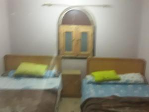 a toy room with two beds and a window at بيت سيدون السياحي in Aswan