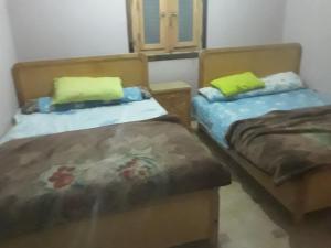 dwa łóżka siedzące obok siebie w pokoju w obiekcie بيت سيدون السياحي w mieście Aswan