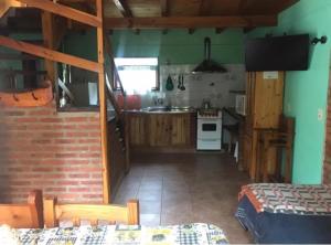 a kitchen with green walls and a kitchen with a stove at Cabaña familiar en pleno centro de Bolsón para 5-6 personas in El Bolsón
