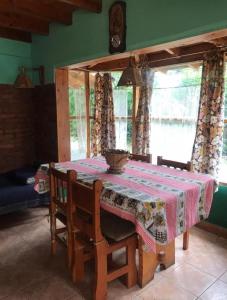 a dining room table with a table cloth on it at Cabaña familiar en pleno centro de Bolsón para 5-6 personas in El Bolsón
