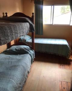 a bedroom with two bunk beds and a window at Cabaña familiar en pleno centro de Bolsón para 5-6 personas in El Bolsón