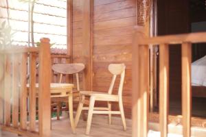 a wooden porch with a table and two chairs at Teba Junjungan Cottages in Ubud