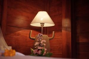 a lamp with horns on a table with flowers at Teba Junjungan Cottages in Ubud