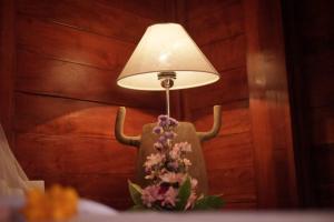 una lámpara con cuernos y flores sobre una mesa en Teba Junjungan Cottages en Ubud