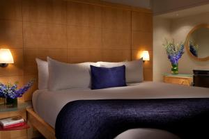 a bedroom with a large bed with a blue pillow at Millennium Premier New York Times Square in New York